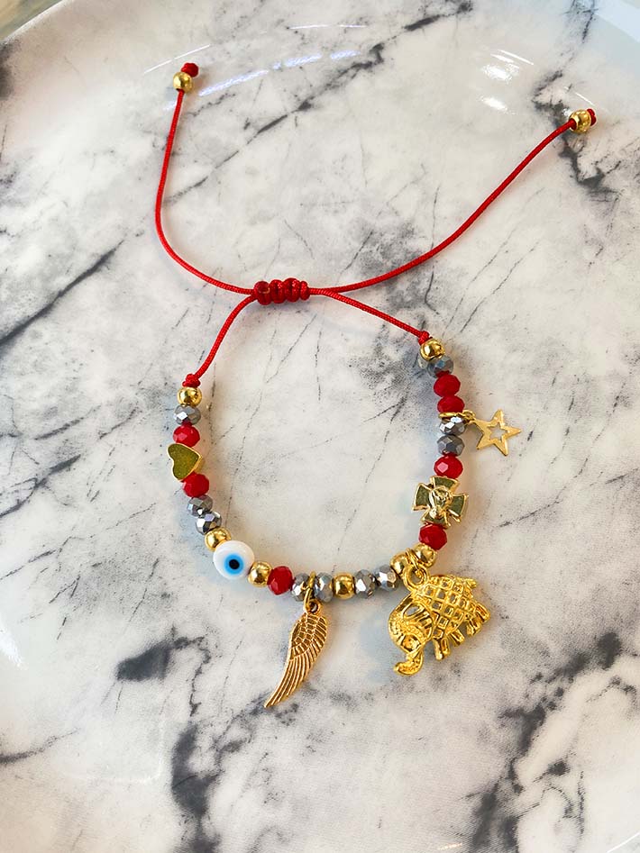 Pulsera en cristales y dijes con baño en oro