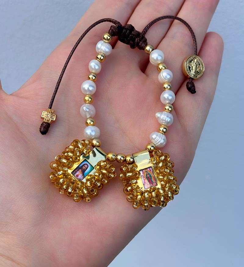 Pulsera de perlas con escapularios dorados